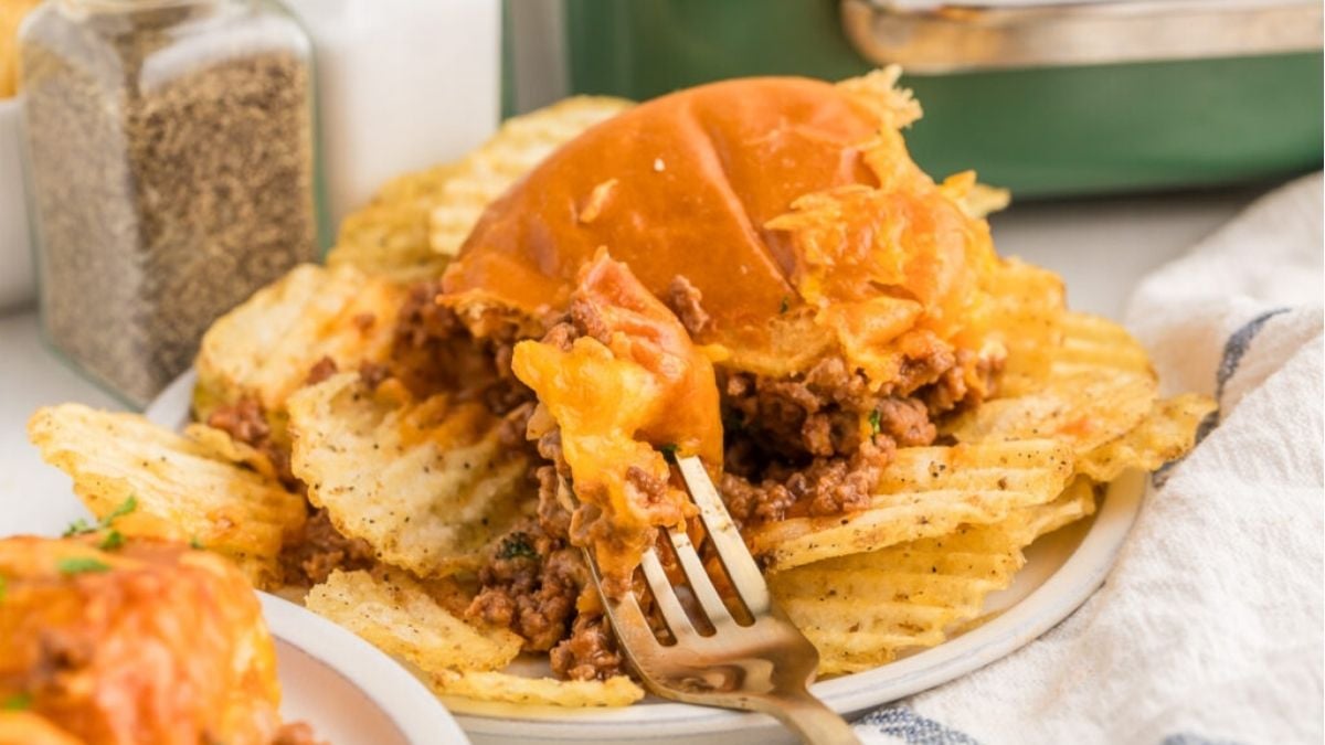 Sloppy Joe casserole served with potato chips on a white plate.