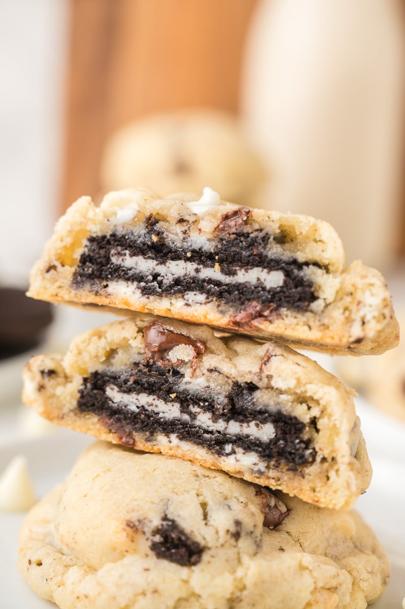Oreo stuffed chocolate chip cookies stacked on a white plate.
