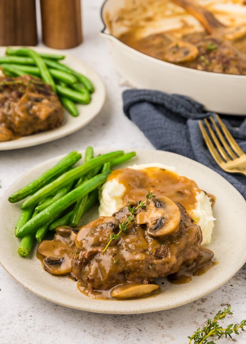 Salisbury steak served with mashed potatoes and green beans.