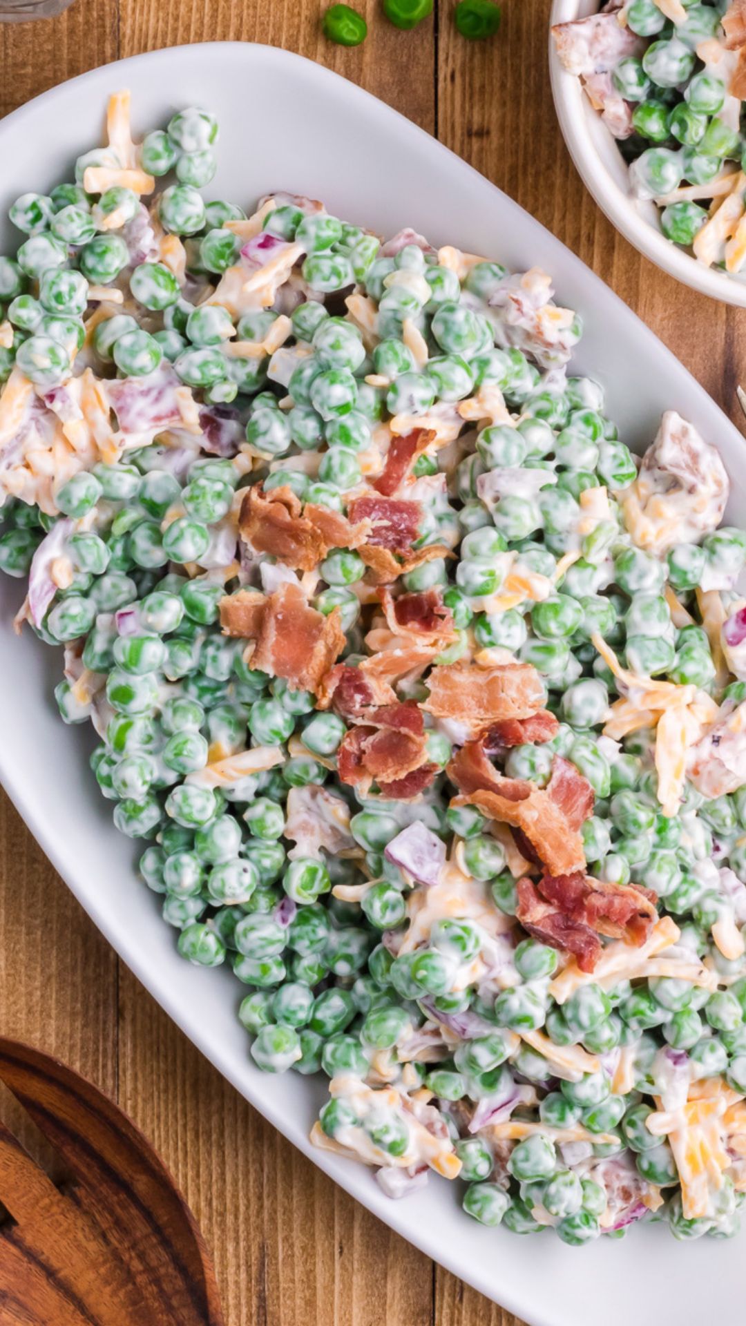 Pea salad with bacon served on a white plate.