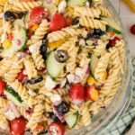 Greek pasta salad in a glass bowl.
