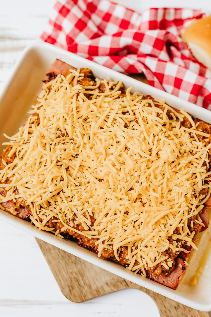 Shredded cheese is sptrad on top of chili.