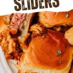Chili cheese dog sliders on a white plate.