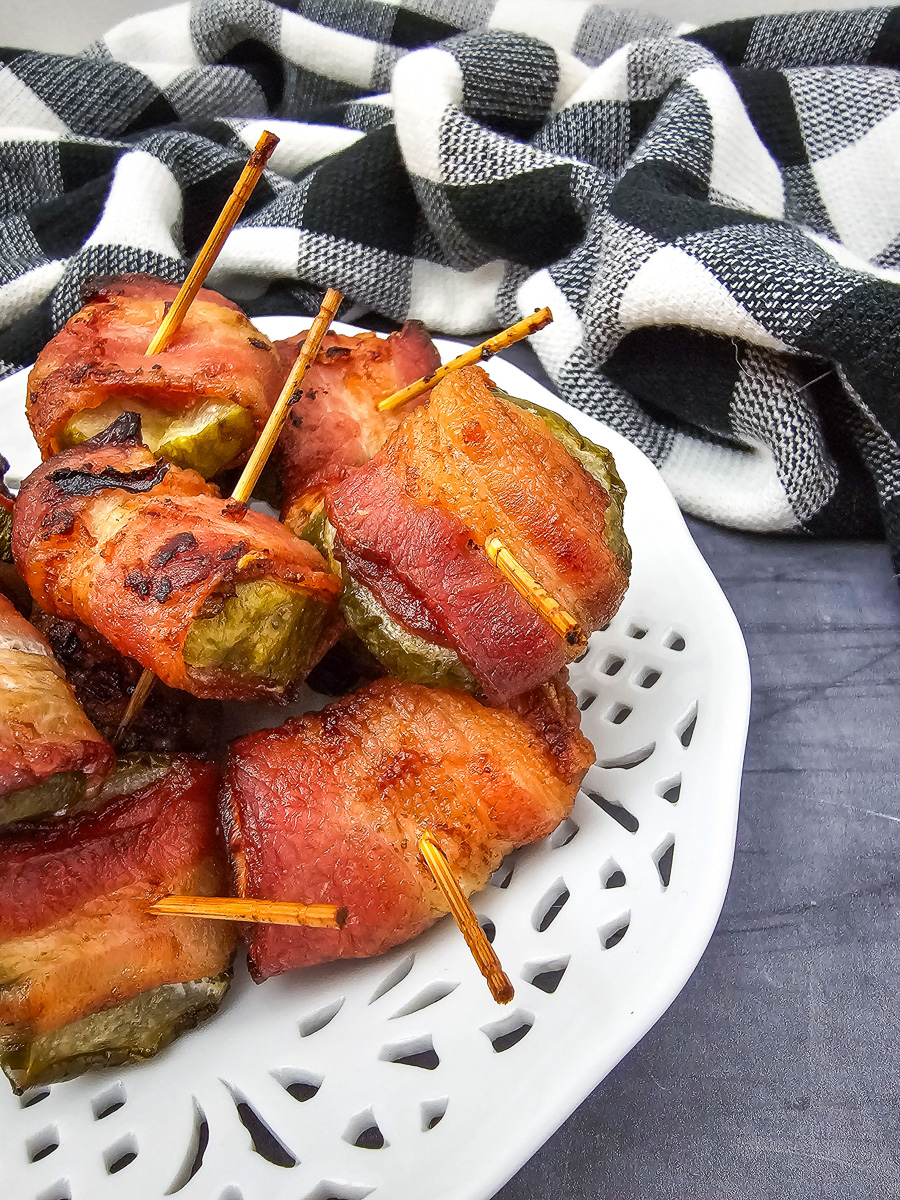 Air fryer bacon wrapped Dilly Bites served on a whtie plate.