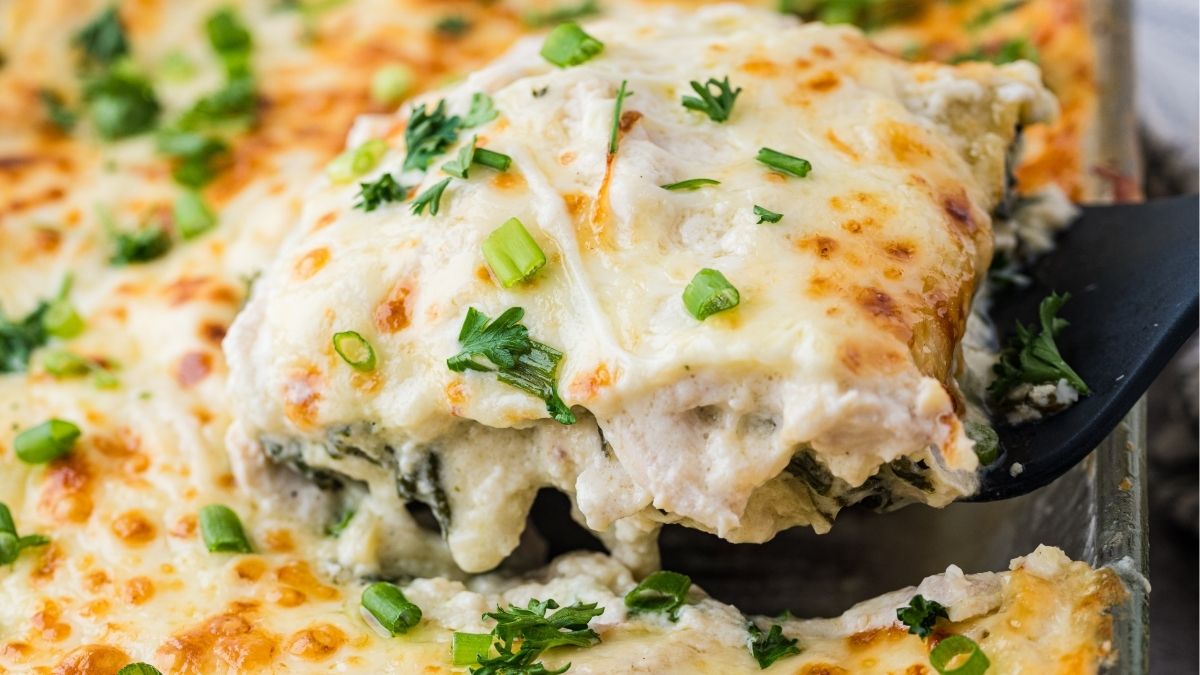 Chicken Alfredo lasagna on a serving spoon.