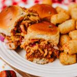 Chili cheese dog sliders on a plate.