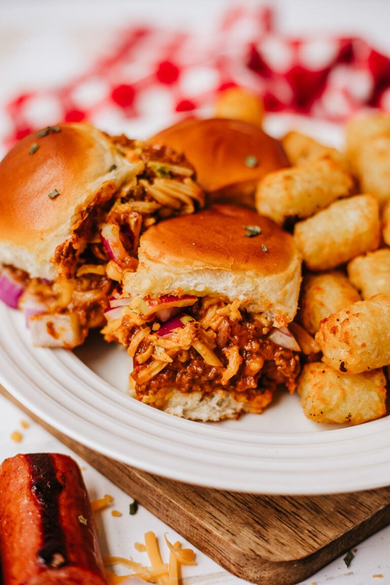 Chili cheese dog sliders on a plate.