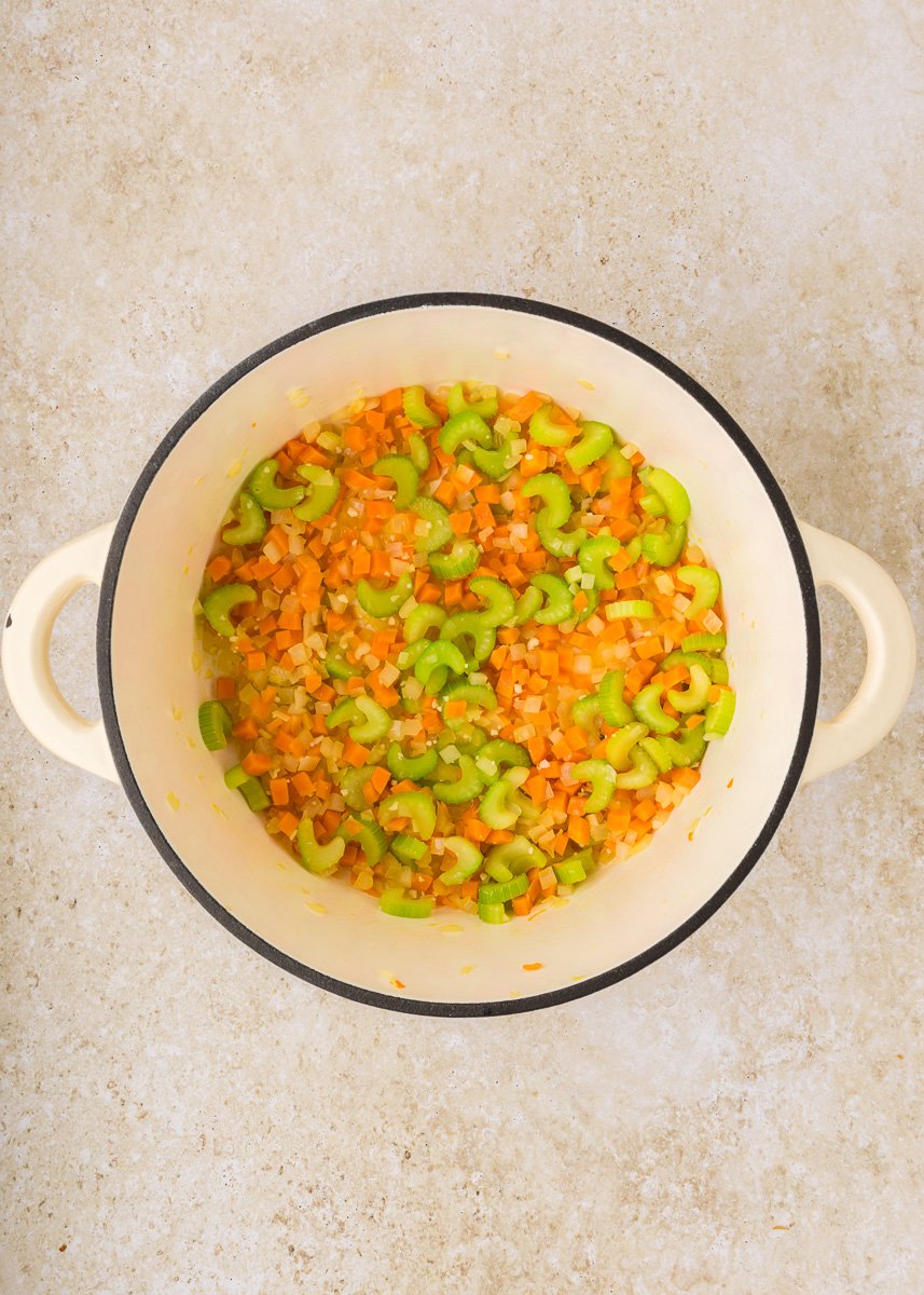Onions, carrots and celery in cooking pot.