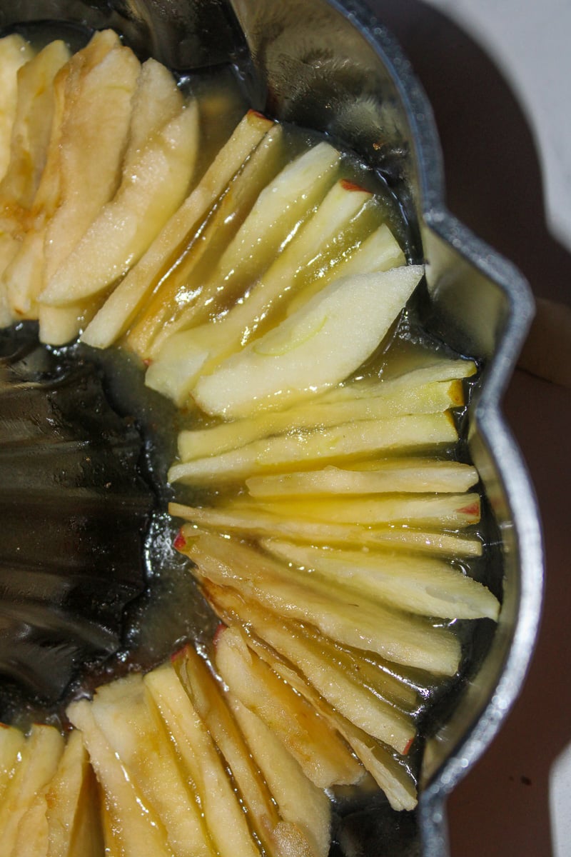 Apple slices placed in bottom of buttered bundt cake pan.