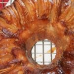 Caramel apple upside down Bundt cake on wire cooling rack.