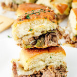 Philly cheesesteak sliders on a white plate.