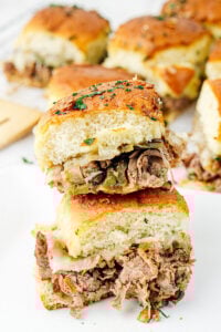 Philly cheesesteak sliders on a white plate.