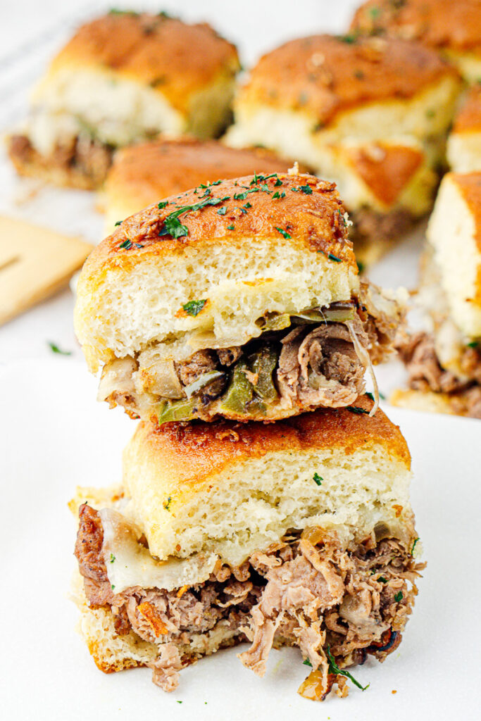 Philly cheesesteak sliders on a white plate.