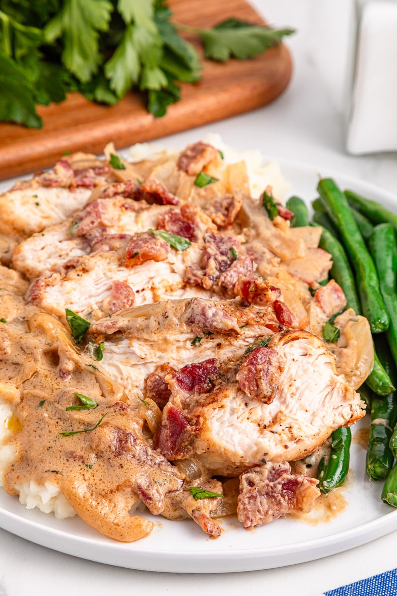 Smothered chicken and gravy with green beans served on a plate.
