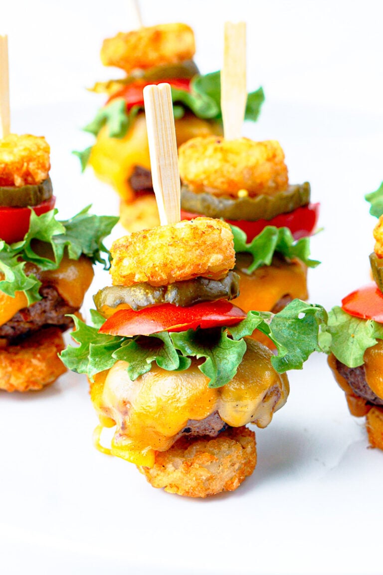 Tater tot mini cheeseburgers on a white plate.