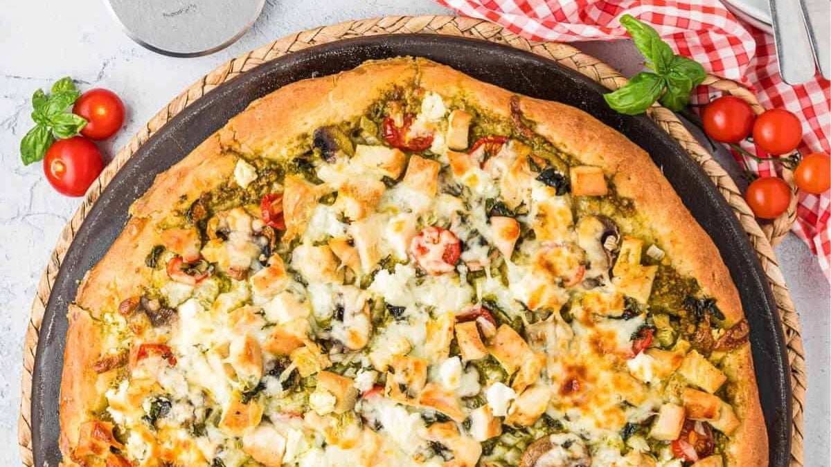 Chicken pesto pizza overhead view in pizza platter reay to be served.