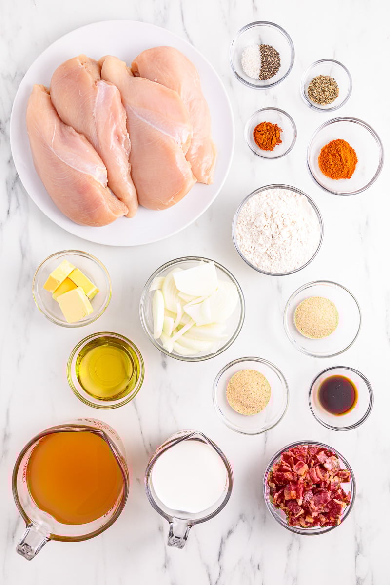 Ingredients for smothered chicken arranged in small bowls on counter.
