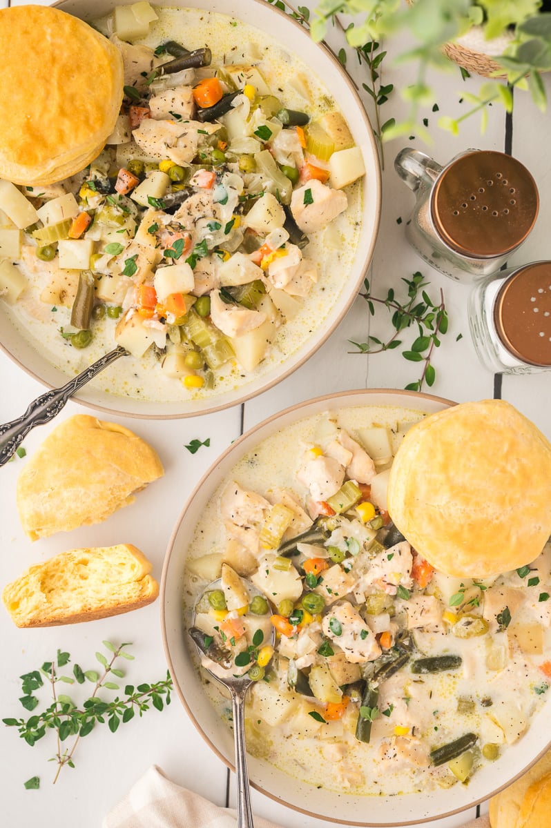 Two bowls of chicken pot pie soup on table.