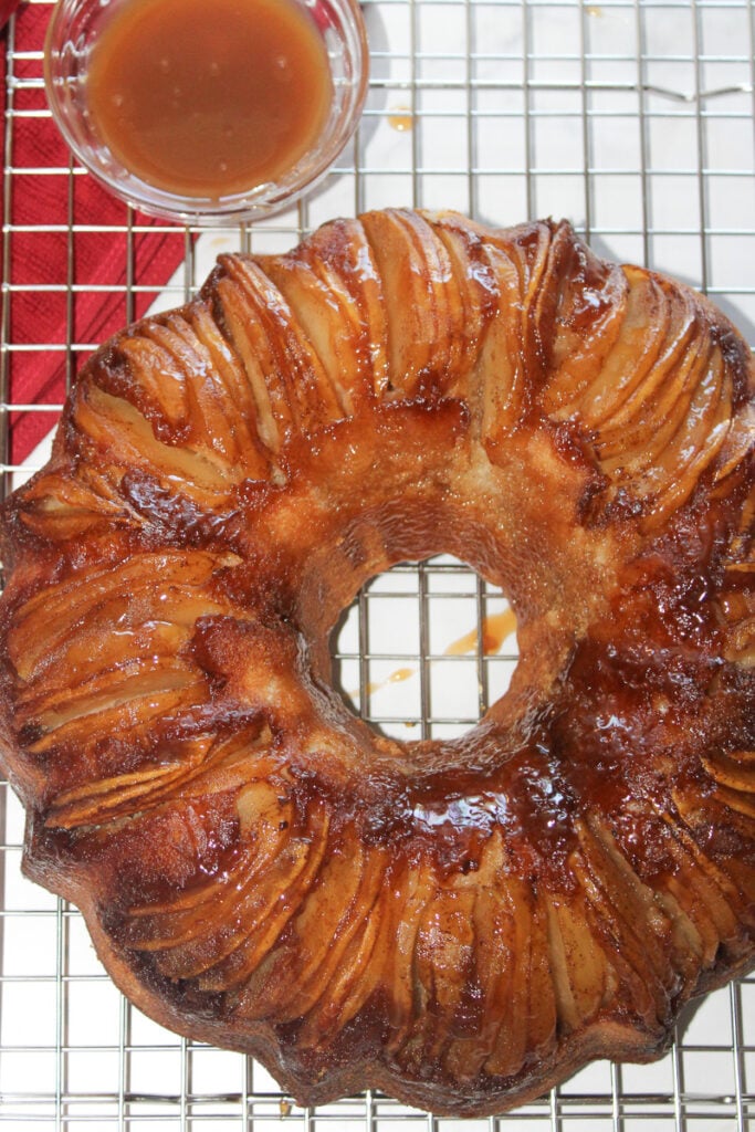 Caramel apple upside down bundt cake on wire cooling rack.