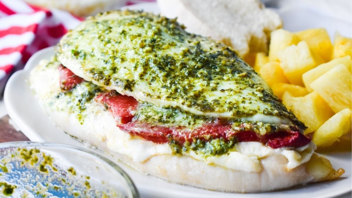 Pesto stuffed chicken on a white plate.