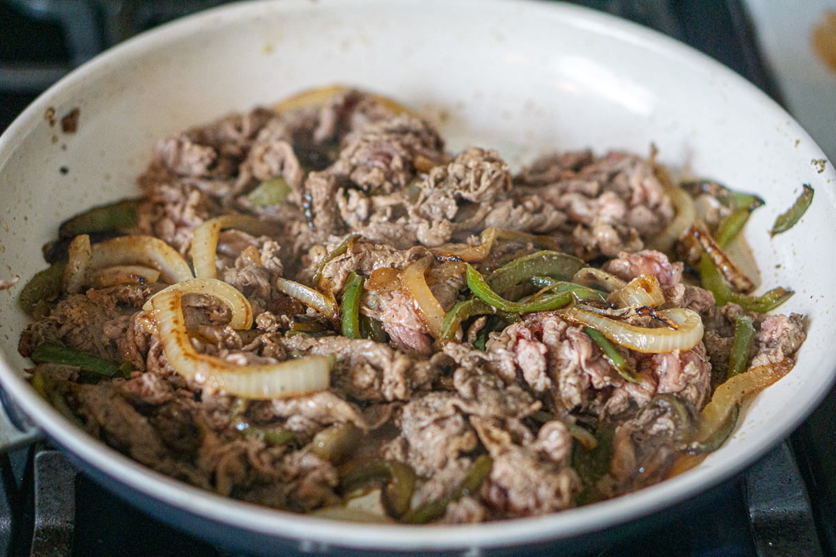 Shaved steak is added to the onion and pepper mixture.