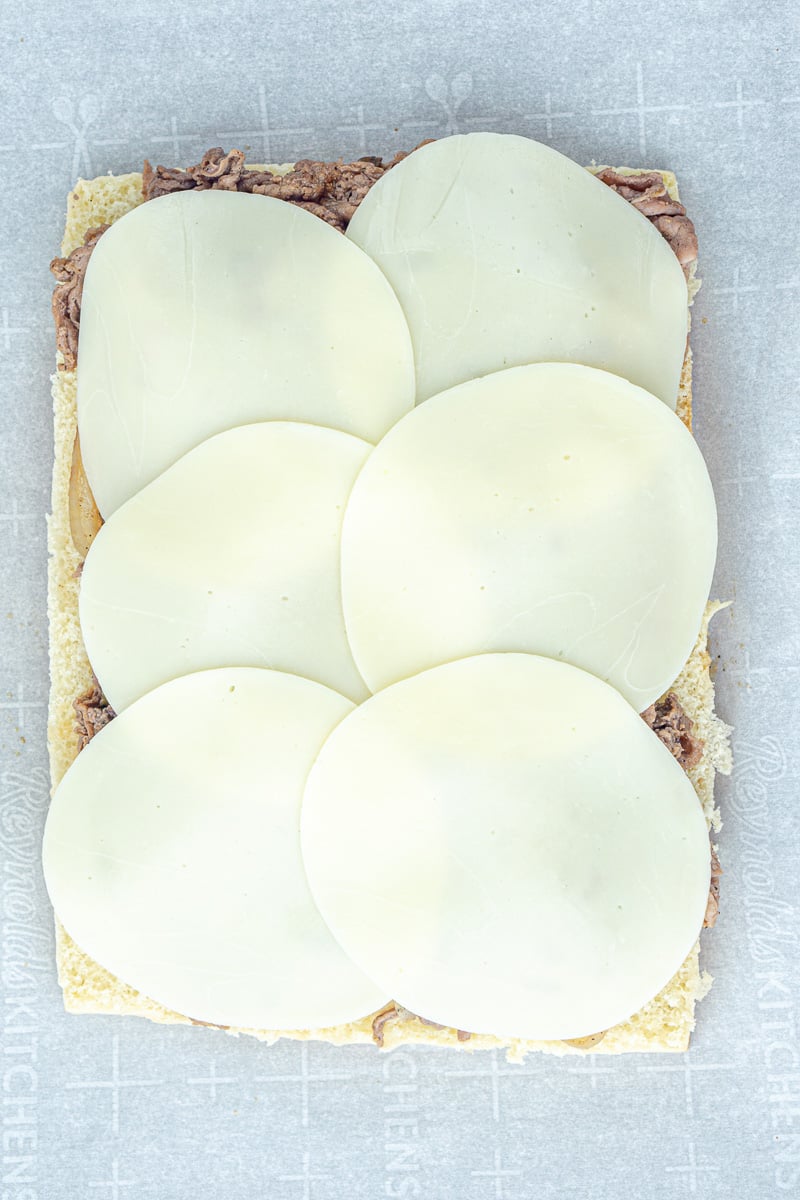 Provolone cheese slices are added to the top of the beef mixture.