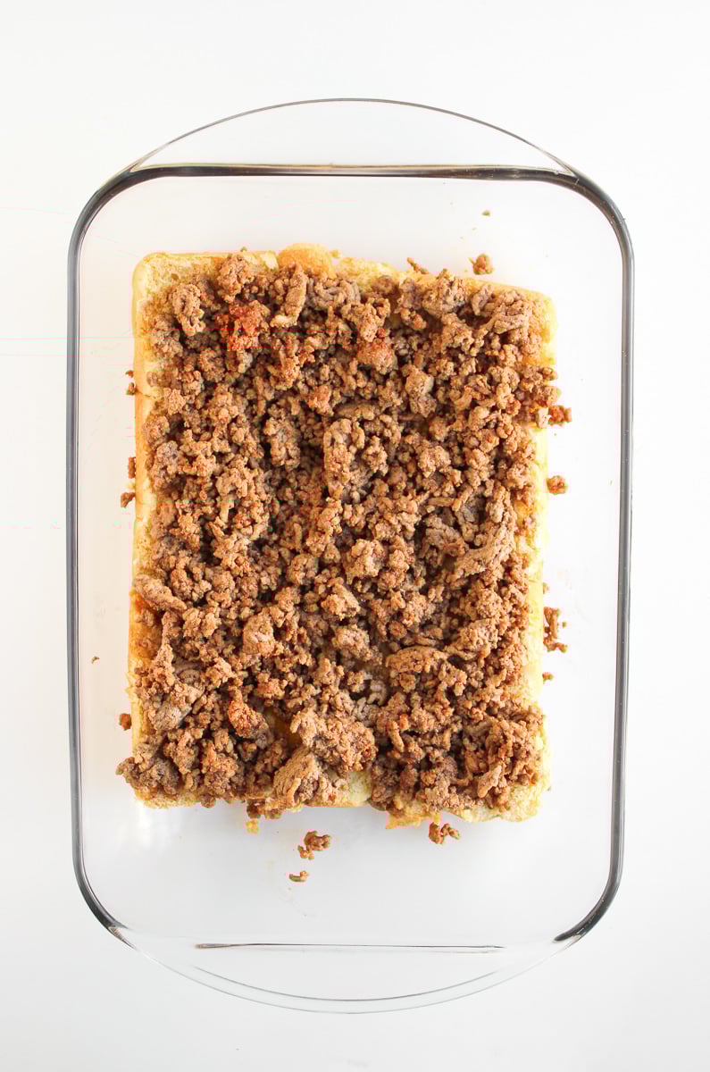 Cooked ground beef is spread on top of sliders.