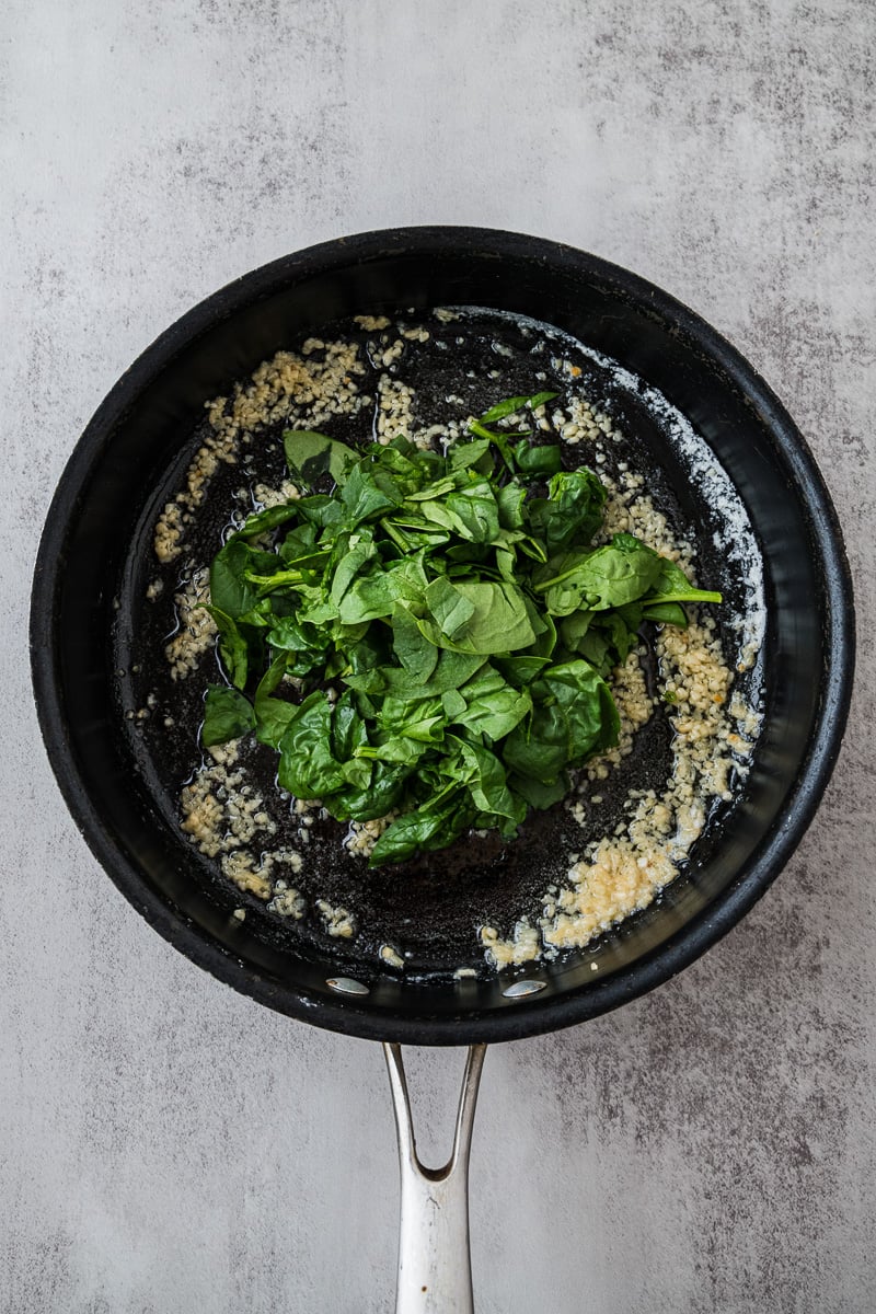 Spinach is added to skillet with the butter and garlic.