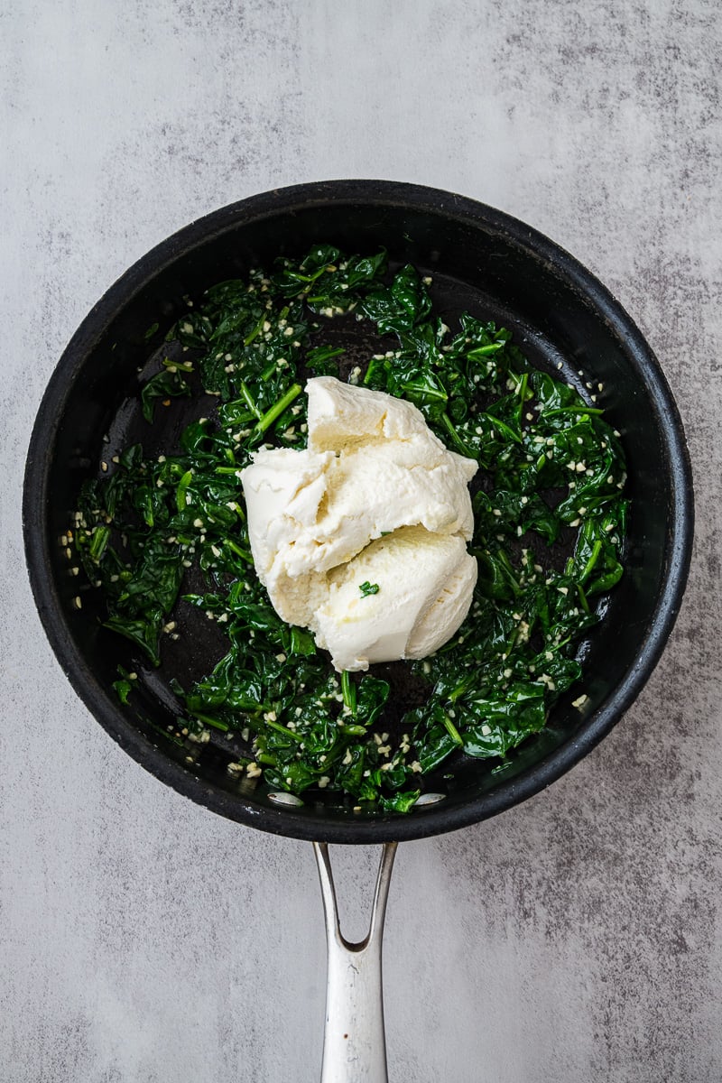 Ricotta is added to the spinach mixture in skillet.