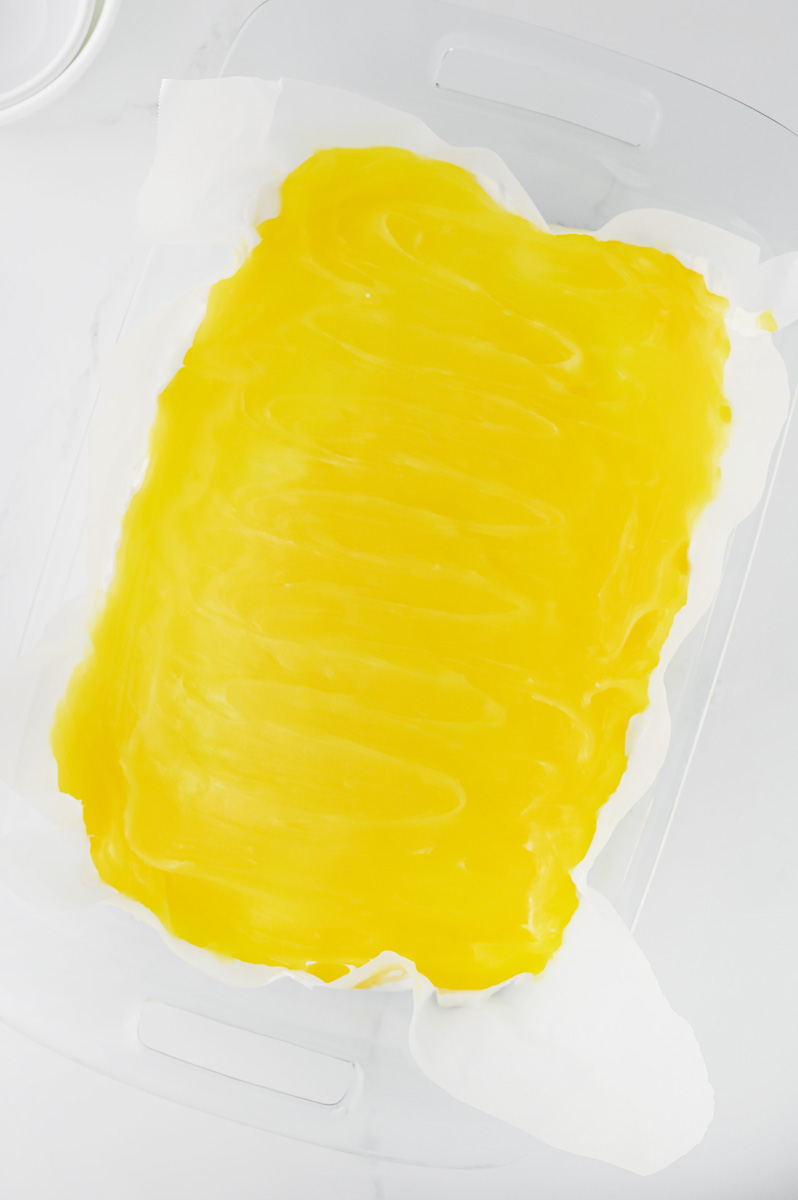 Lemon pie filling is spread on top of the cream cheese layer.