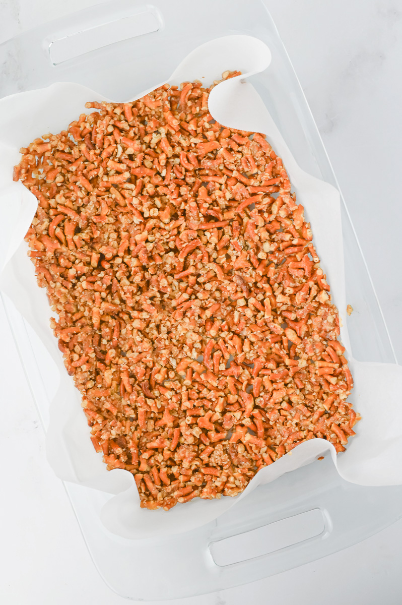 Pretzel mixture is pressed into the bottom of a 9x13-inch baking dish.