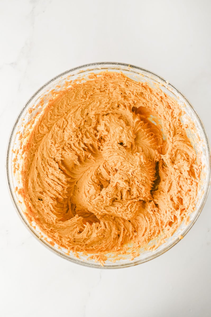 Pumpkin puree is added to the sugar mixture in mixing bowl.