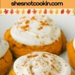 Pumpkin cookies with cream cheese frosting on a white plate.