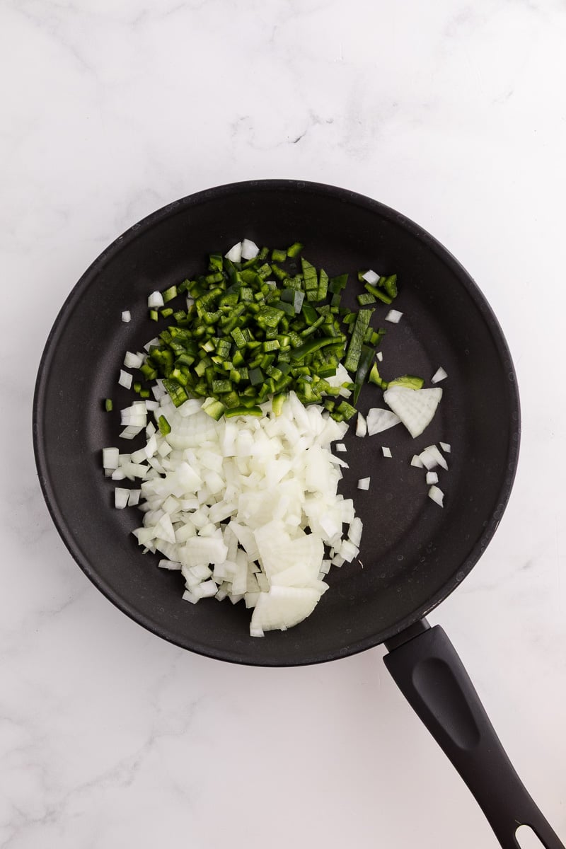 Onion and poblano peppers in skillet with olive oil.