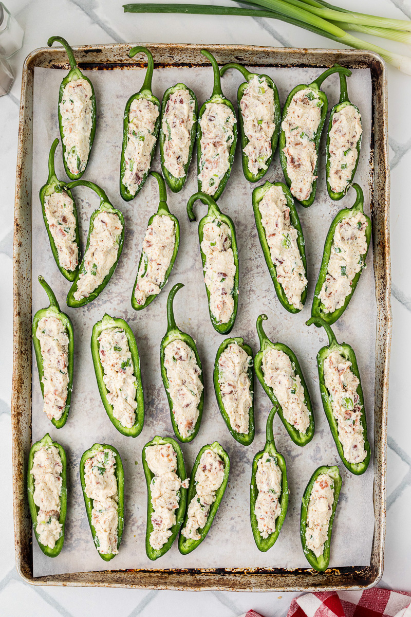 Jalapenos with filling placed in single layer on baking sheet.