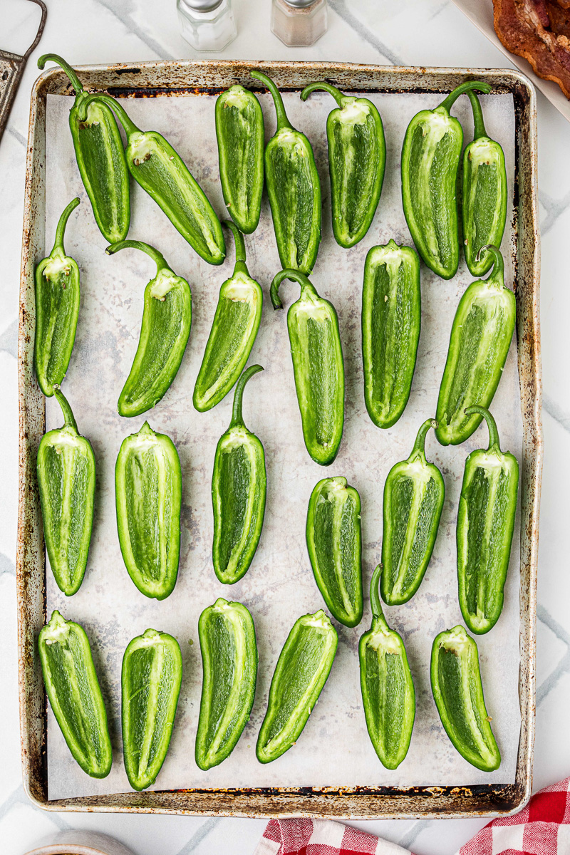 Jalapenos sliced and seeded placed in single layer on baking sheet.