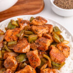 Black pepper chicken served on a white plate.