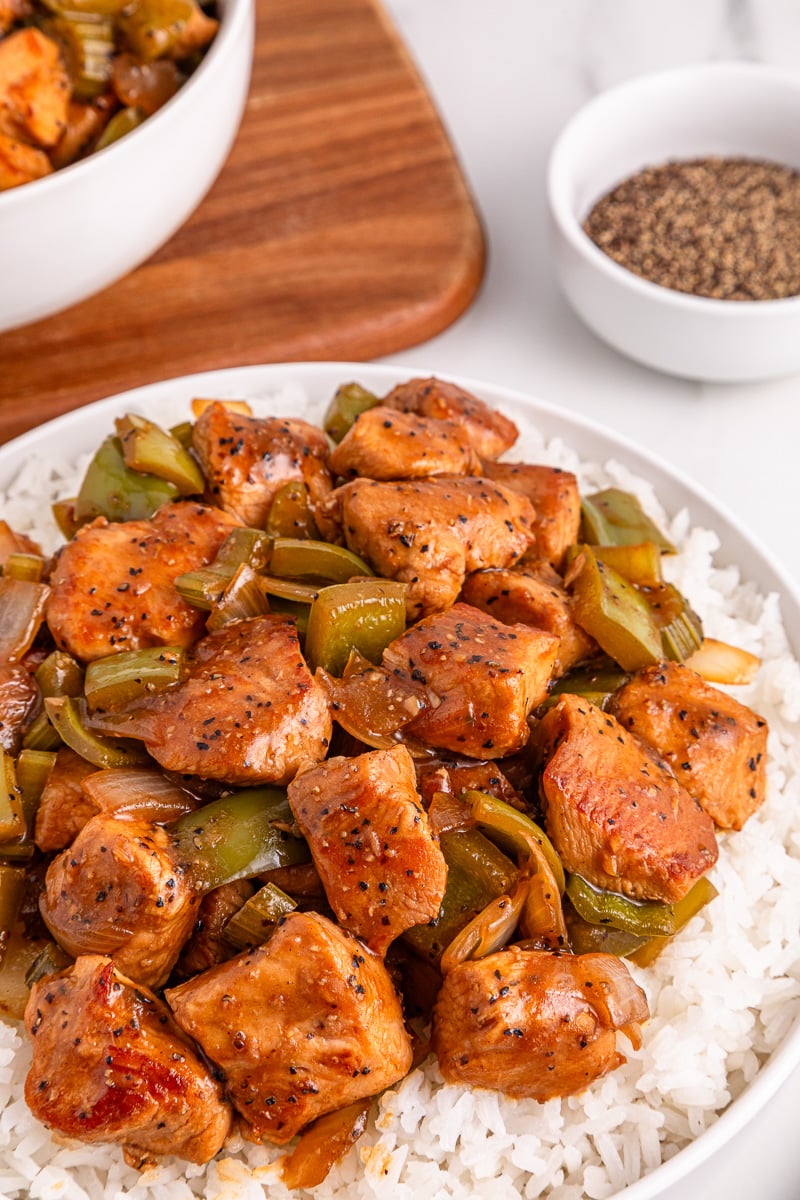 Black pepper chicken served on a white plate.