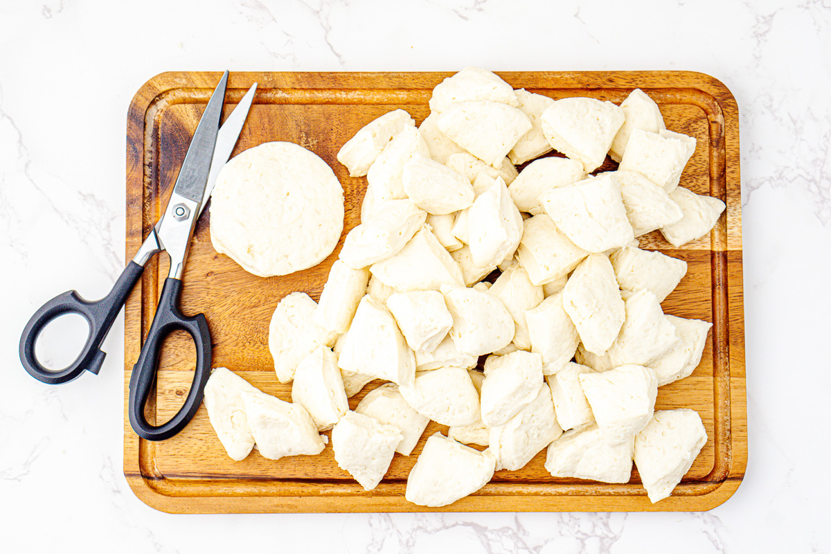 Biscuits are cut up on cutting board.