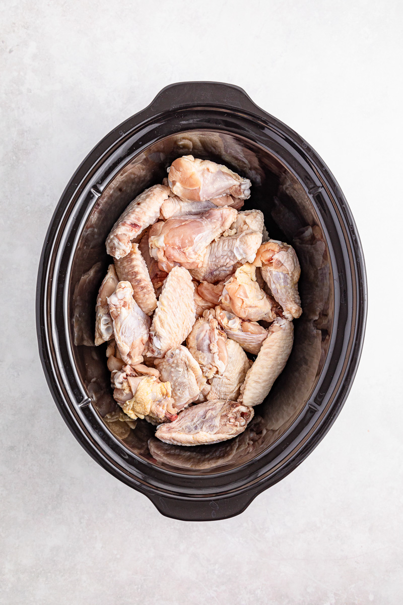 Chicken wings in bottom of slow cooker.
