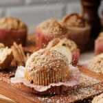 Muffins with paper removed on wooden board.