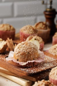 Apple cinnamon crumb muffin on a wooden board.