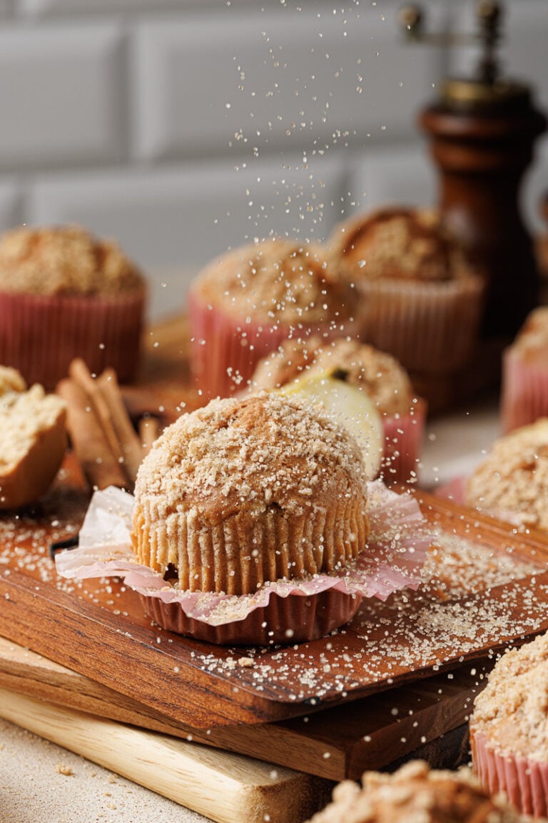 Apple cinnamon crumb muffin on a wooden board.