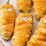 Jalapeno popper mummies served on a white plate.