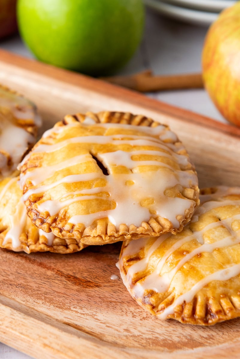 Apple hand pies on wooden board.