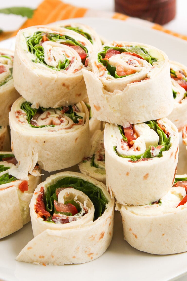 BLT pinwheels stacked on a plate.