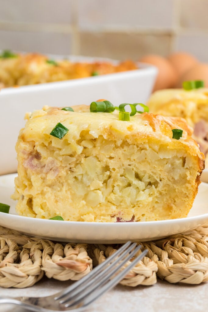 Tater tot breakfast casserole served on a white plate.