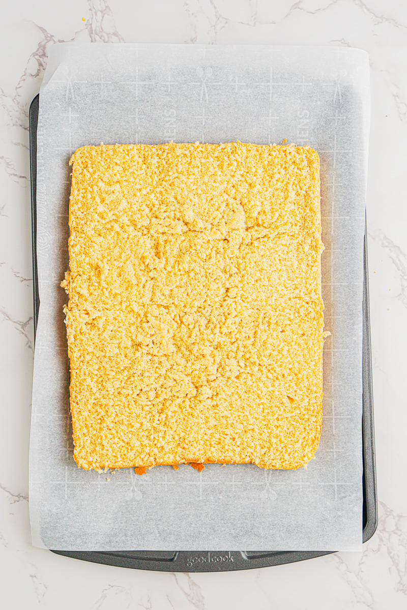 Bottom of sliers placed on baking sheet that is lined with parchment paper.