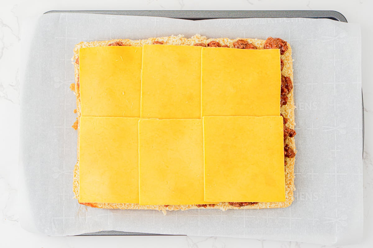 Cheese is sptread on top of the meat mixture.