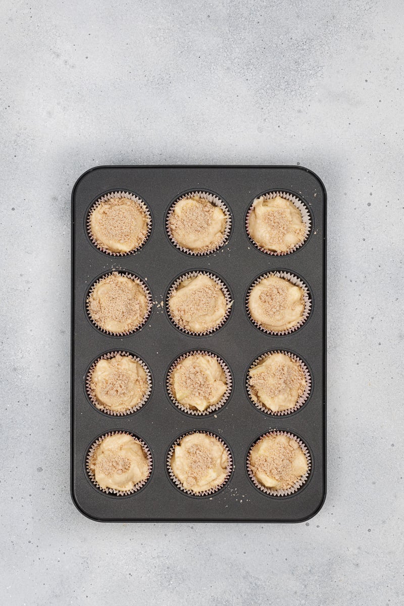 Crumb topping is sprinkled on top of the muffin batter.